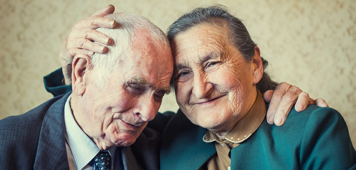 sweet elderly couple with their heads tilted together