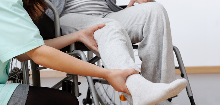 A man in a wheelchair being assisted by a staff member