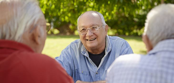 Three men sitting together outside talking