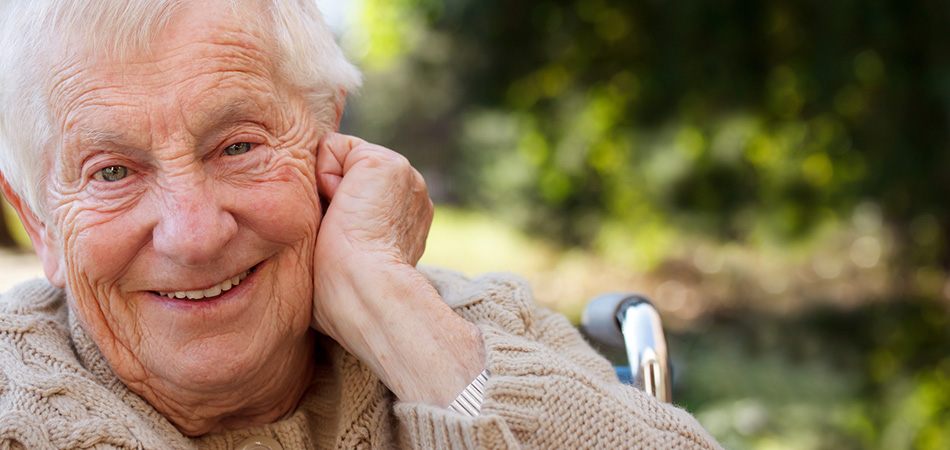 An elderly man smiling in his wheelchair