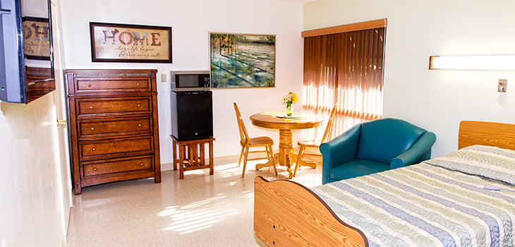 Resident room with clean floors and sunshine coming in through the windows