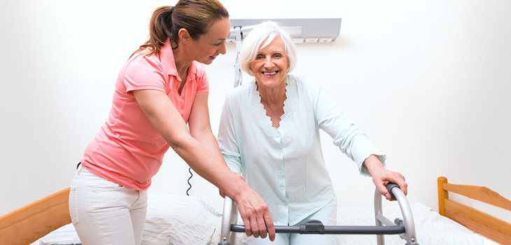 Rehabilitation staff working with a resident using her walker