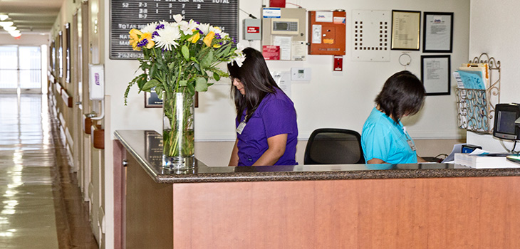 Nurses station with two nurses inside actively working