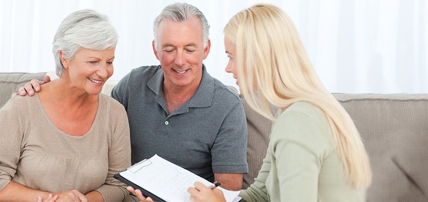 A couple sitting with a staff member going over paperwork