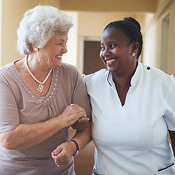 nurse walking with resident down a hallway