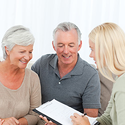 couple signing paperwork with a staff member